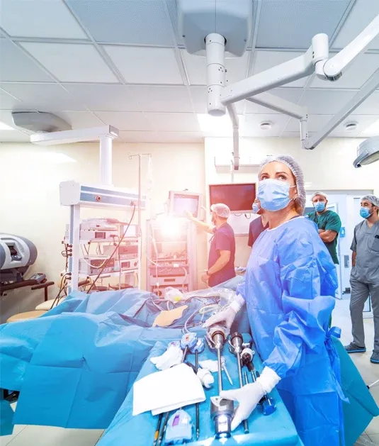 Pflegefachperson im OP-Saal bereitet medizinische Instrumente während eines chirurgischen Eingriffs vor.