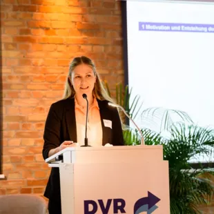 a woman giving a speech at a podium