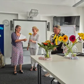 three people attending a graduation ceremony in a classroom