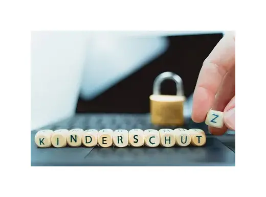 Holzbuchstaben bilden das Wort „Kinderschutz“, daneben steht ein Vorhängeschloss auf einer Tastatur.