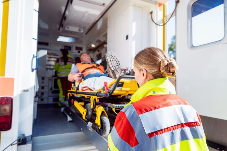 Rettungssituation mit Einsatzkräften des Rettungsdienstes beim Transport einer Person in einen Rettungswagen.